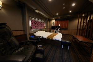 Habitación con cama y silla. en ROOM袖ヶ浦 -Adult Only- en Sodegaura