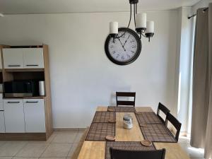a dining room with a table and a clock on the wall at Comfortable and roomy, in Sonsonate in Sonsonate