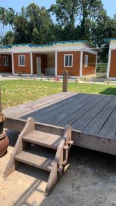 a wooden deck with a bench on top of a building at Meraga Cinta Kijal in Kijal