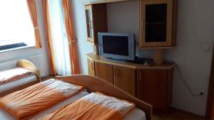 um quarto com uma cama e uma televisão num armário em Houses and Apt in Smarjeske Toplice Kranjska Krain 26042 em Smarjeske Toplice