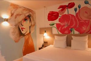 a painting of a woman on the wall of a bedroom at Inn OZZ Astana in Astana