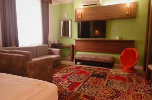 a hotel room with a bed and a living room at Inn OZZ Astana in Astana