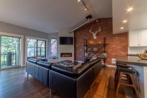 a living room with a leather couch and a brick wall at #521- Luxury Remodeled, Mid-Town Condo in Mammoth Lakes