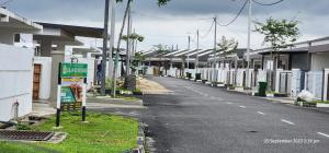 an empty street next to a row of houses at D'Haty Homestay in Padang Serai