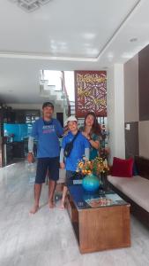 un groupe de trois personnes debout dans un salon dans l'établissement Hoài River Hội An Homestay Sông Hoài Homestay 250m walk to the center Old Town, à Hội An