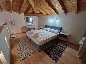 una camera con un grande letto in una stanza con pavimenti in legno di Christos Katerina House a Pythagóreion
