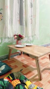 Homestay YẾN HÒA في Ấp Bình Hưng: طاولة خشبية موضوعة على الأرض في غرفة