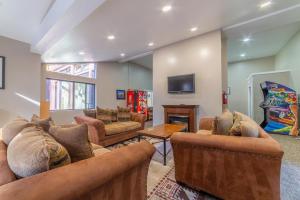 a living room with couches and a flat screen tv at #278 Ski-in, Ski-out Corner unit with View in Mammoth Lakes