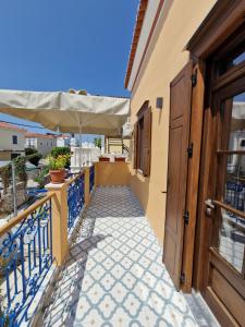 a balcony with an umbrella and a walkway at Christos Katerina House in Pythagoreio