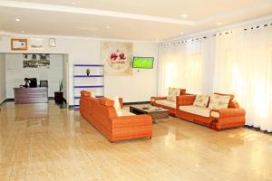 uma sala de estar com dois sofás e uma televisão em Fatmols Hotels em Lusaka