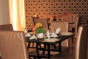 a dining room table with chairs and a black table with flowers at Fatmols Hotels in Lusaka +22 photos