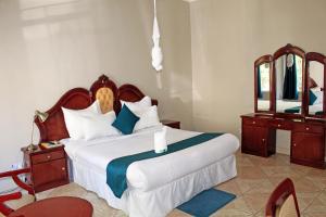 1 dormitorio con 1 cama grande y espejo en Fatmols Hotels, en Lusaka