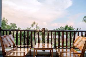 2 sillas y mesa en un balcón con vistas en Cosiana Resort, en Phu Quoc