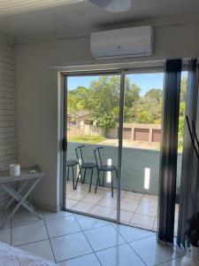 a room with a patio with chairs and a sliding glass door at Beytell's Nest in Richards Bay