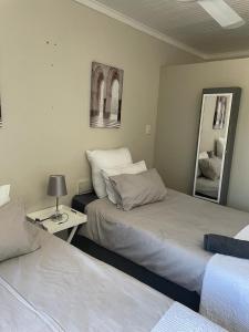 a bedroom with two beds and a table with a mirror at Beytell's Nest in Richards Bay