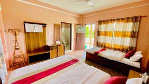 a hotel room with two beds and a mirror at Hotel Tree Tops in Sauraha
