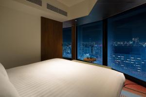 Postel nebo postele na pokoji v ubytování HOTEL GROOVE SHINJUKU, A PARKROYAL Hotel