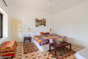 1 dormitorio con 1 cama y 1 mesa en StayVista's Gaudhuli Farmstay - Outdoor Pool & Terrace with View, 