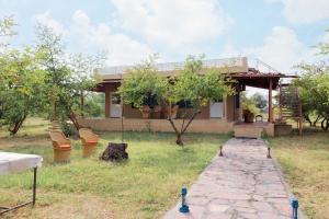 una casa con un pabellón delante de un patio en StayVista's Gaudhuli Farmstay - Outdoor Pool & Terrace with View, 