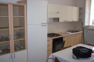 una cucina con frigorifero e tavolo con borsa; di Suite Apartments a Cervia