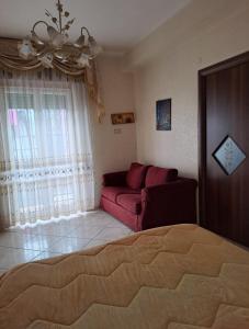 a living room with a red couch and a window at Casa Imma Napoli in Naples