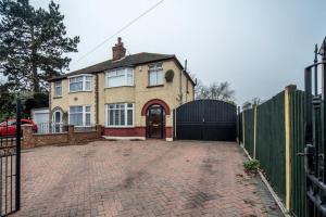 une maison avec un portail et une allée en briques dans l'établissement 3 mins from the theme park! Charming Bedford Hideaway!, à Kempston