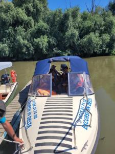 dos personas en un barco en el agua en Casa Badea, en Murighiol