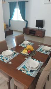 una mesa de comedor con platos y fruta. en The T Villa, en Protaras
