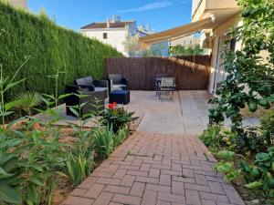a patio with chairs and plants in a backyard at Apartament Ca la Rosa in L'Ampolla