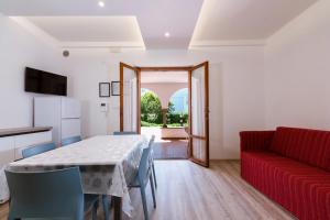 a dining room with a table and a red couch at Residence Elle in San Benedetto del Tronto