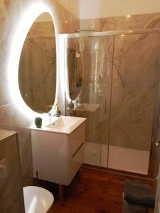 y baño con lavabo y ducha con espejo. en LA MAISON DU SOLEIL, en LʼIsle-Jourdain