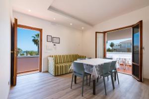 a dining room with a table and chairs and a couch at Residence Elle in San Benedetto del Tronto