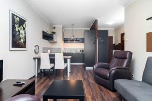 a living room with a couch and a table at Apartamenty Platinum Inowroclawska Wrocław by Renters in Wrocław