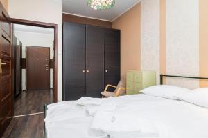 a bedroom with a large white bed and a mirror at Apartamenty Platinum Inowroclawska Wrocław by Renters in Wrocław