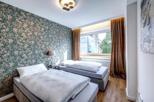two beds in a room with a window at Vendum Living in Essen