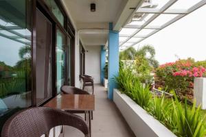 een balkon met een tafel, stoelen en planten bij Casa Noah in Tagaytay