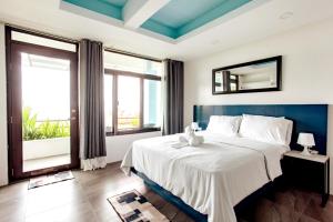um quarto com uma grande cama branca e janelas em Casa Noah em Tagaytay
