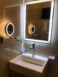 La salle de bains est pourvue d'un lavabo blanc et d'un miroir. dans l'établissement el edén, à Zacatecas