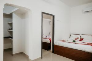 a bedroom with a mirror next to a bed at RD VILLA in Perundurai