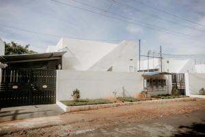 a white house with a black gate at RD VILLA in Perundurai
