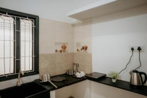 a kitchen with a black counter and a window at RD VILLA in Perundurai