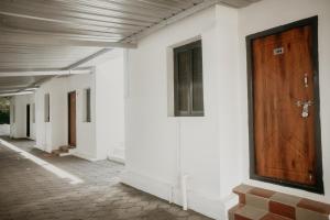 a hallway with a wooden door on a white building at RD VILLA in Perundurai