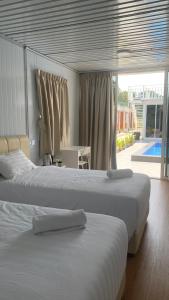 a bedroom with two beds and a view of a pool at Meraga Cinta Kijal in Kijal