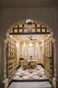 a person sitting at a table in a room with an archway at Dev Mahal - A Boutique Heritage Hotel in Jaipur