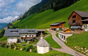un pueblo en las montañas con una colina verde en Voppichlhof App Alpenrose, en San Giacomo