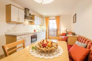 Una cocina con una mesa con un bol de fruta encima. en Voppichlhof App Alpenrose, en San Giacomo