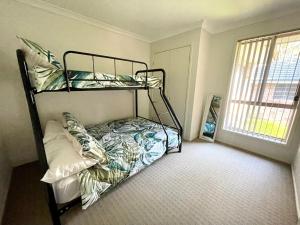 a bedroom with a bunk bed and a window at Leafy Retreat in Ulladulla