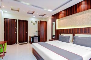 a bedroom with a large bed and a desk at Super Collection O Motisarai Near Birla Mandir in Kolkata