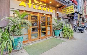 a restaurant with potted plants in front of a building at Staybook Hotel Atlanta New Delhi Train Station in New Delhi