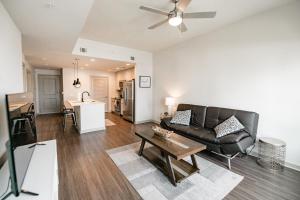 sala de estar con sofá de cuero negro y mesa en Uptown Furnished Apartments near BOA Stadium apts, en Charlotte